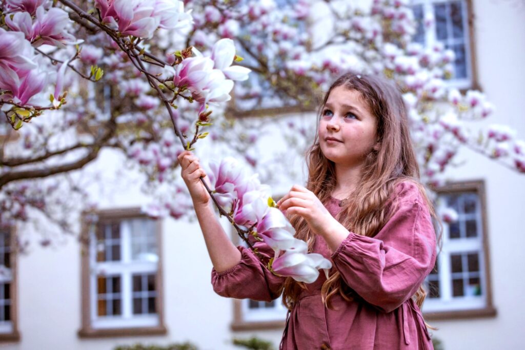 Magnolie Soulangeova (Magnolia × soulangeana) a dívka (zdroj: Envato)